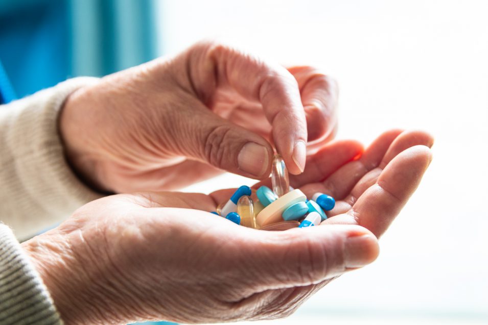 Senior woman hand picking pill