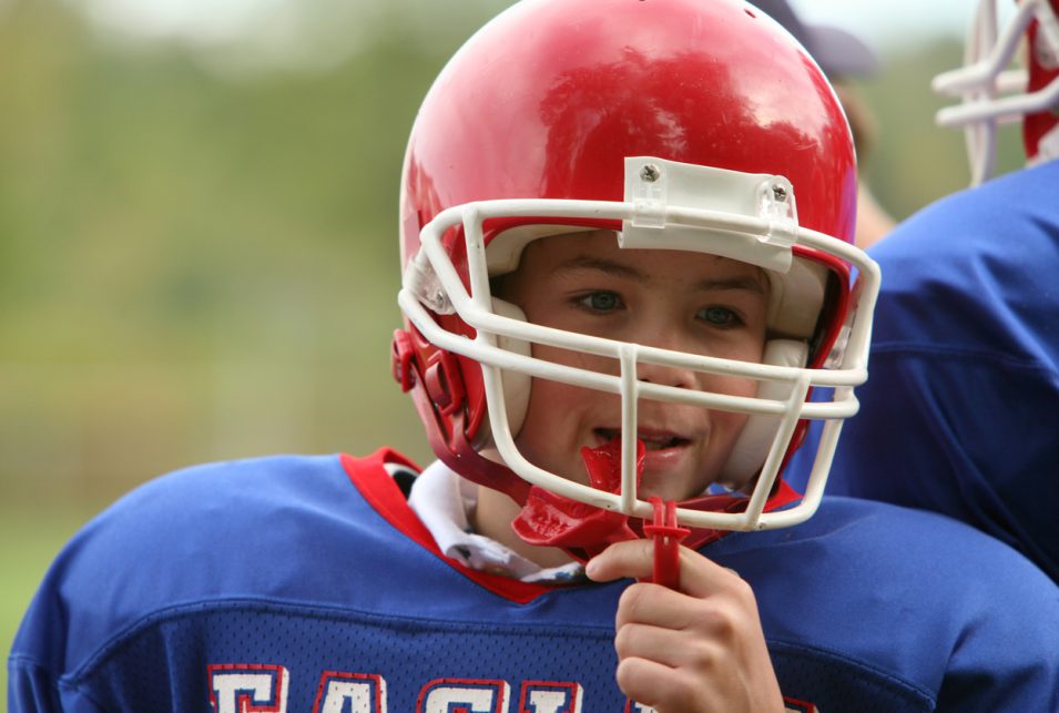 A young boy with an American Football uniform
