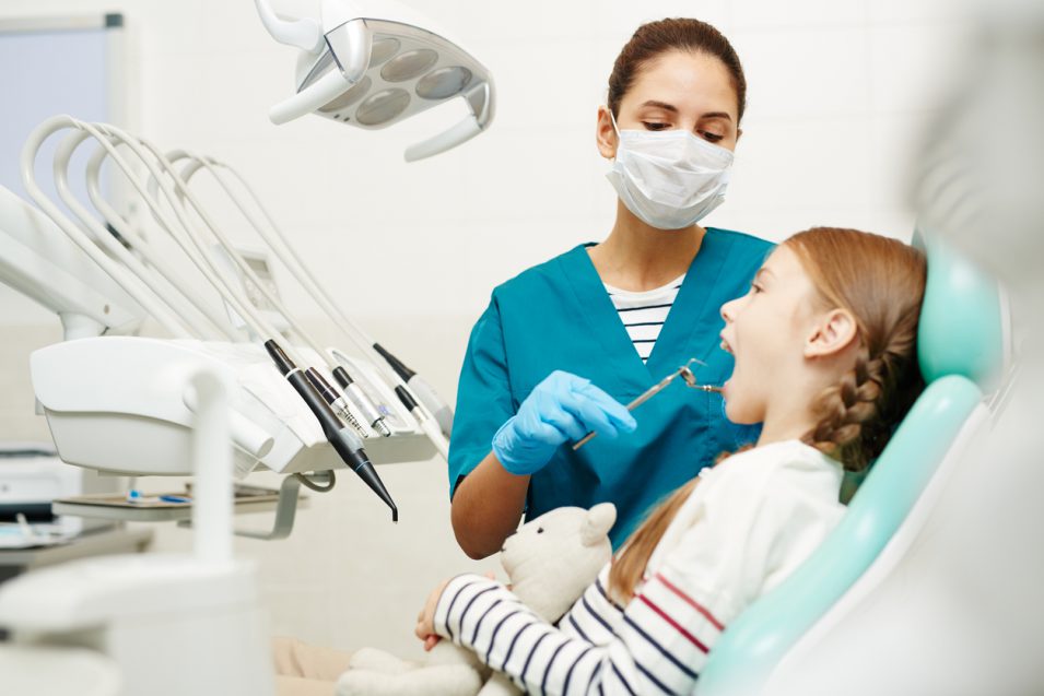 pediatric dentist performing dental treatment